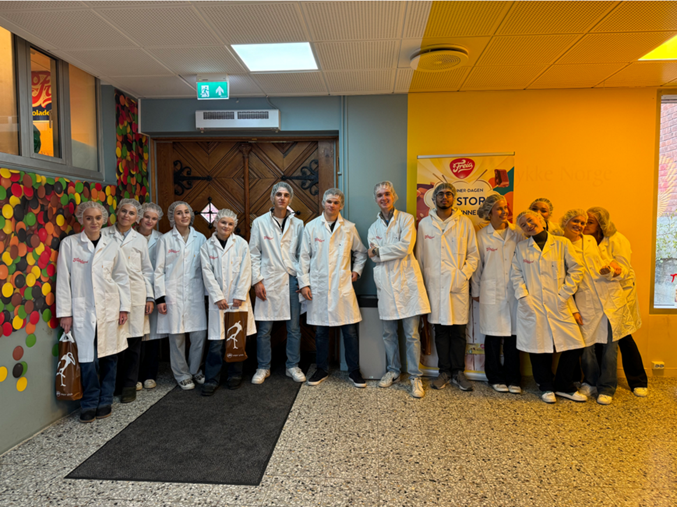 en gruppe mennesker i hvite laboratoriefrakker som står i en gang