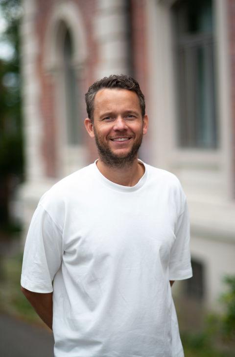 en person som smiler til kameraet