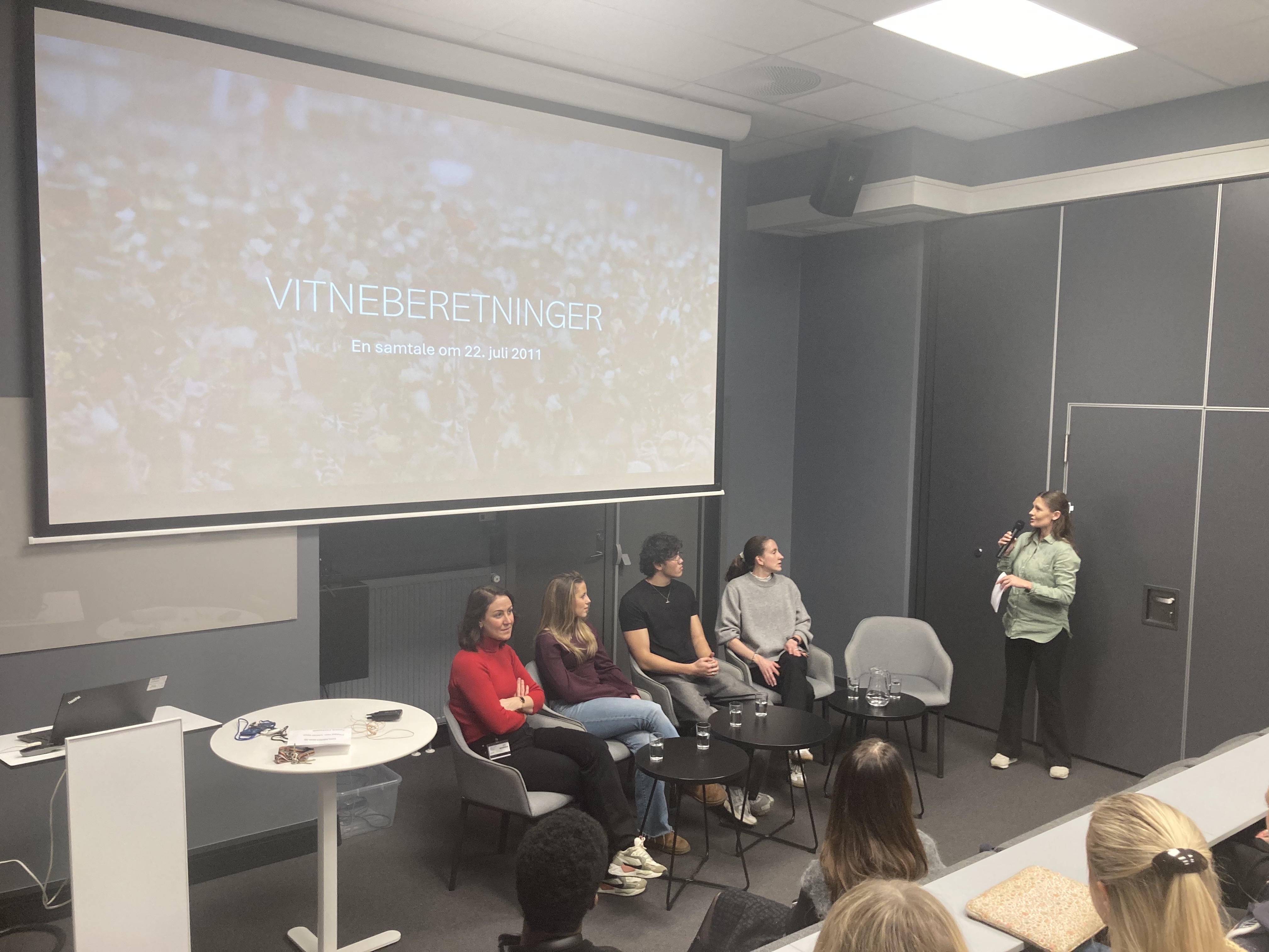 en gruppe mennesker som sitter i stoler foran et projektorlerret