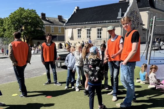 En gruppe mennesker står på et gresskledd felt