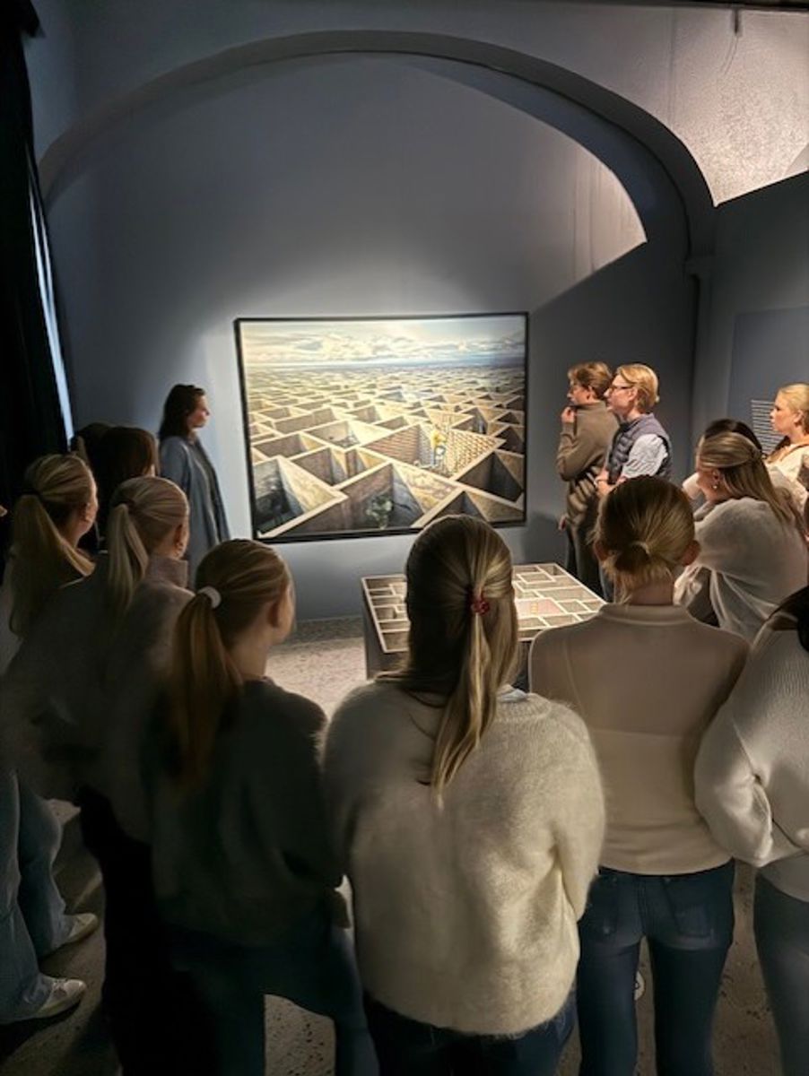 En gruppe mennesker som ser på et maleri på en vegg