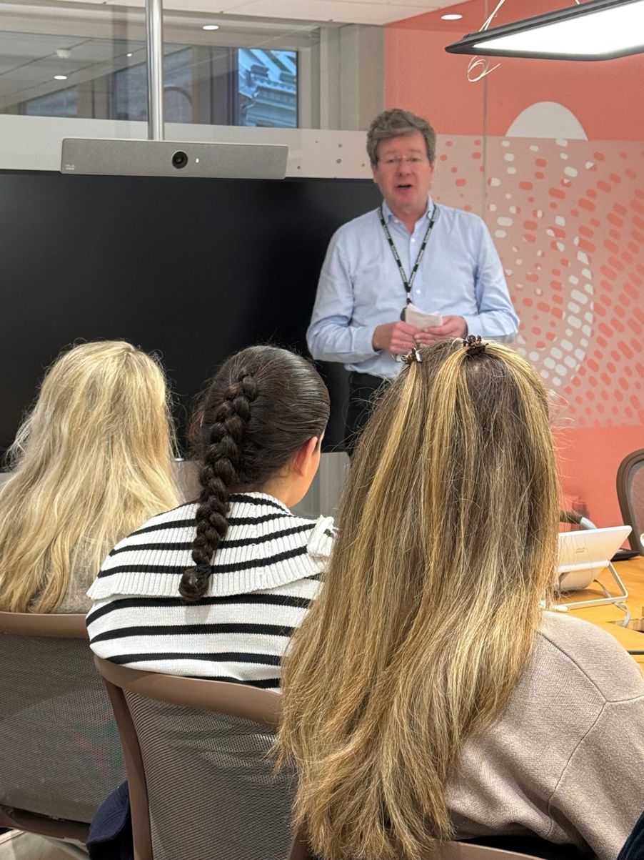 en person som står foran en gruppe mennesker en person som står foran en gruppe mennesker