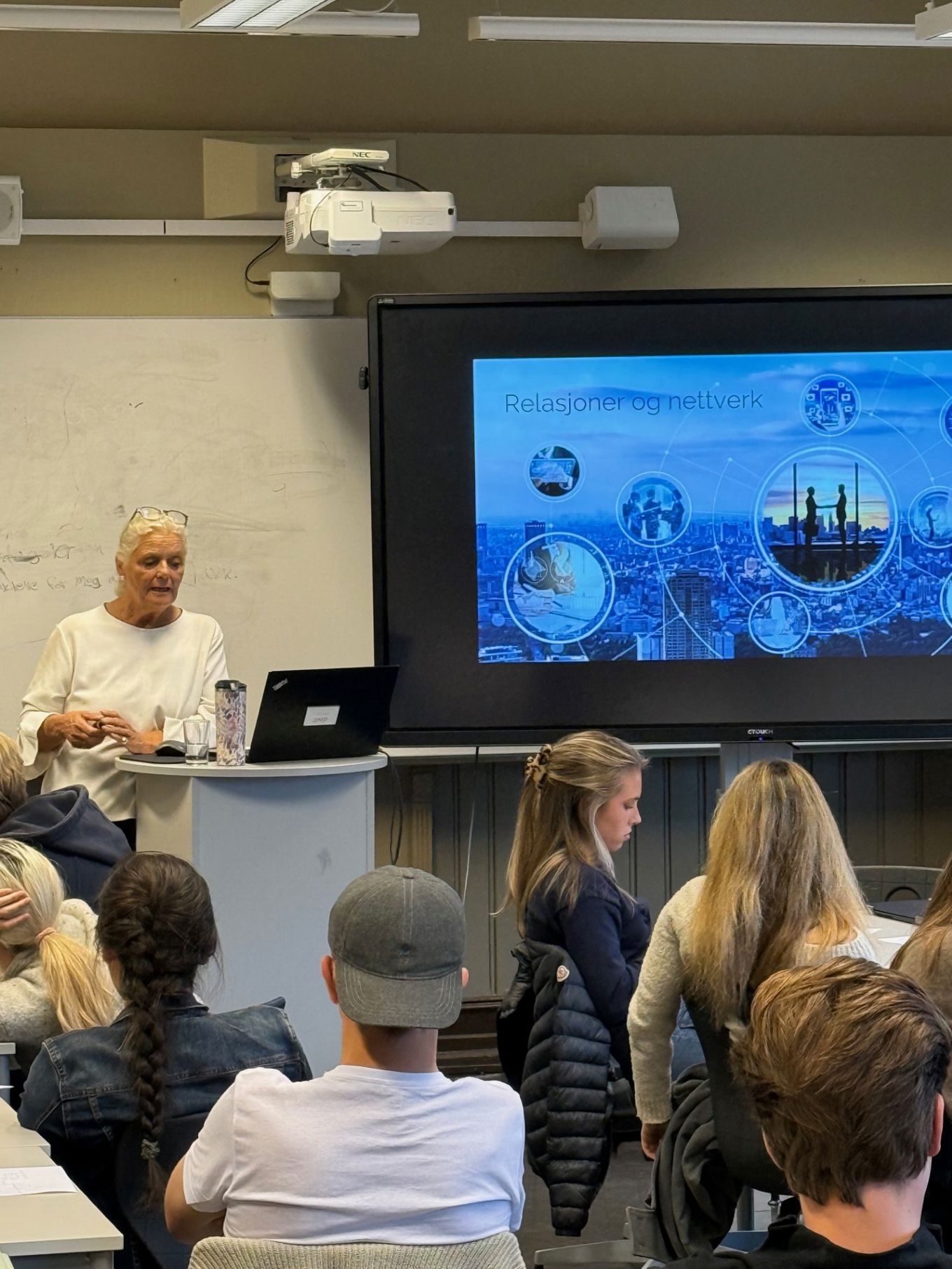 en person som holder en presentasjon for en gruppe mennesker