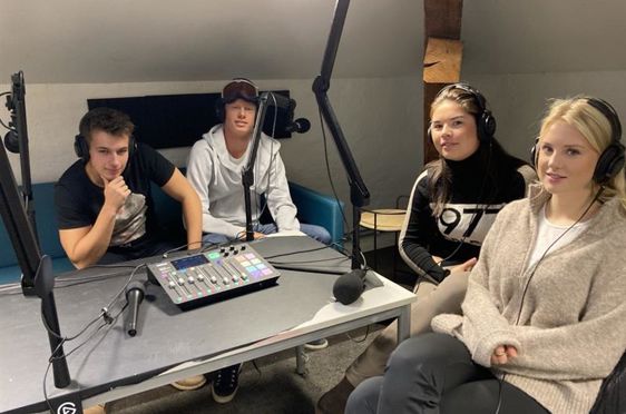 en gruppe mennesker som sitter rundt et bord med en datamaskin