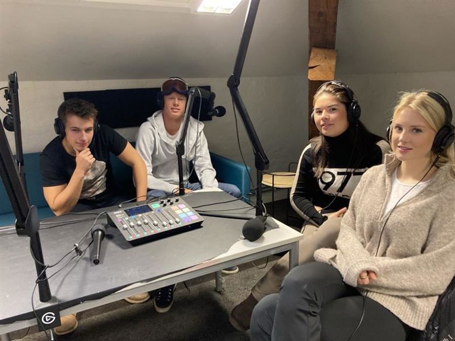 en gruppe mennesker som sitter rundt et bord med en datamaskin