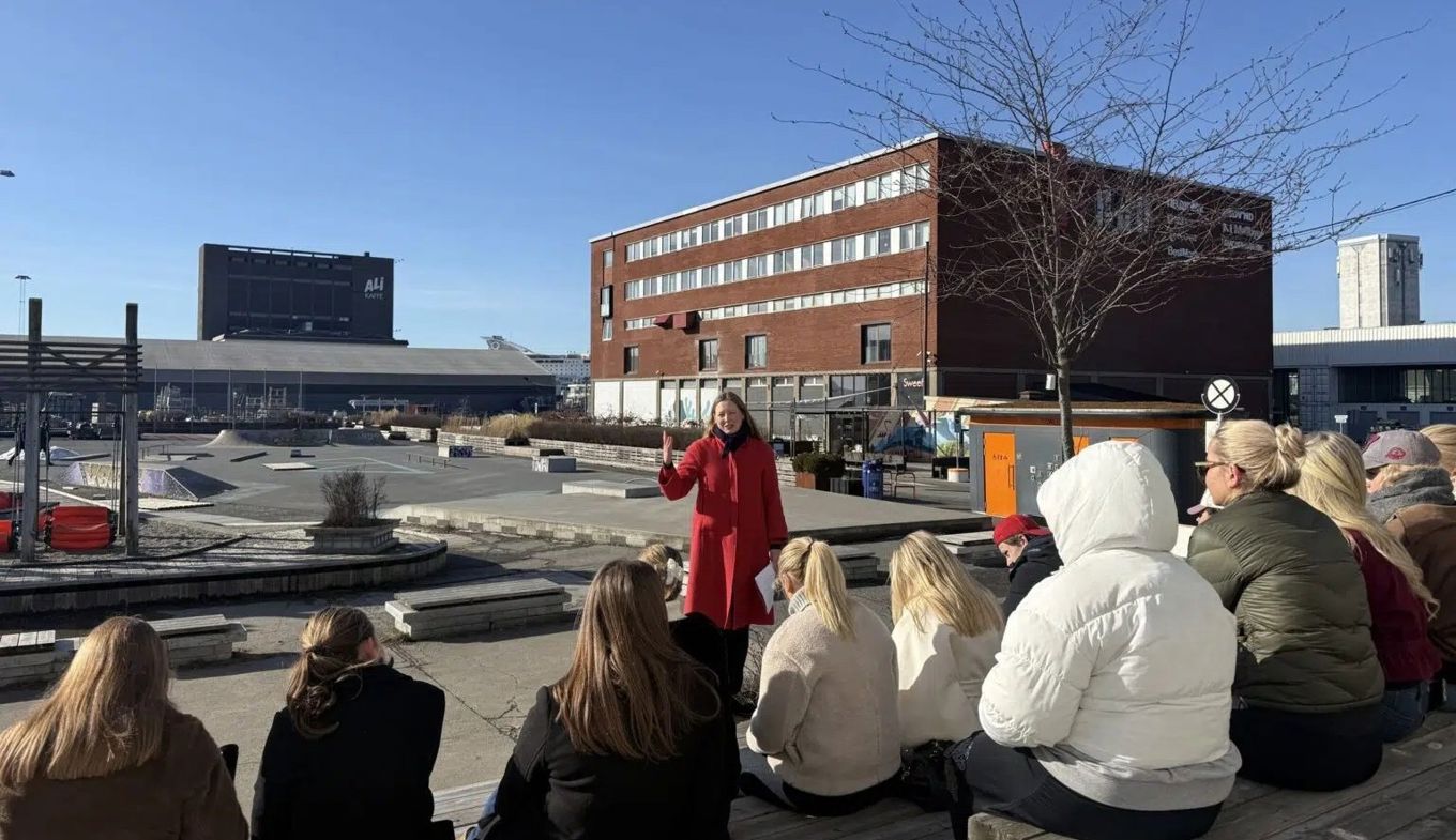 en gruppe mennesker som sitter på bakken utenfor